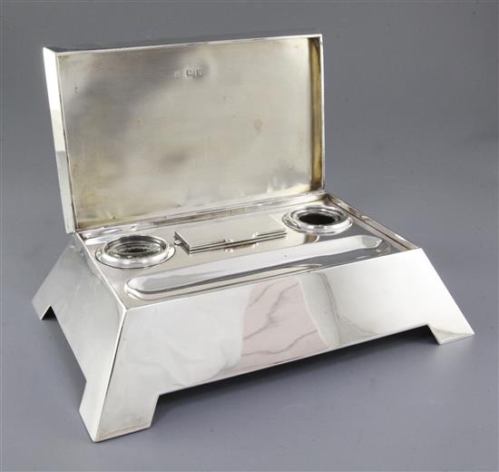 A stylish Edwardian silver inkstand with hinged cover, by length approx 11 ½”/292mm depth 7 ¾”/197 mm. Weight 57ozs/1613grms.
